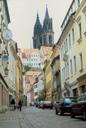 Cobbled street approach to Meissens hilltop palace with giant, black church towers rising above.
